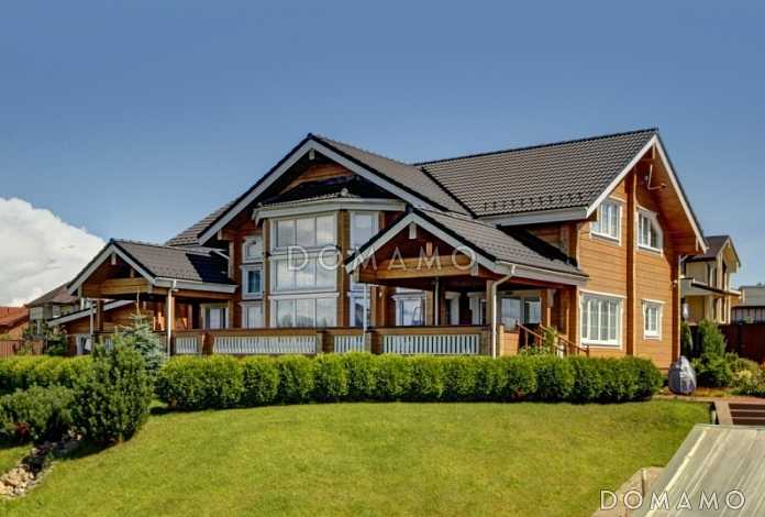 Проект дома из клееного бруса с обилием окон различной формы